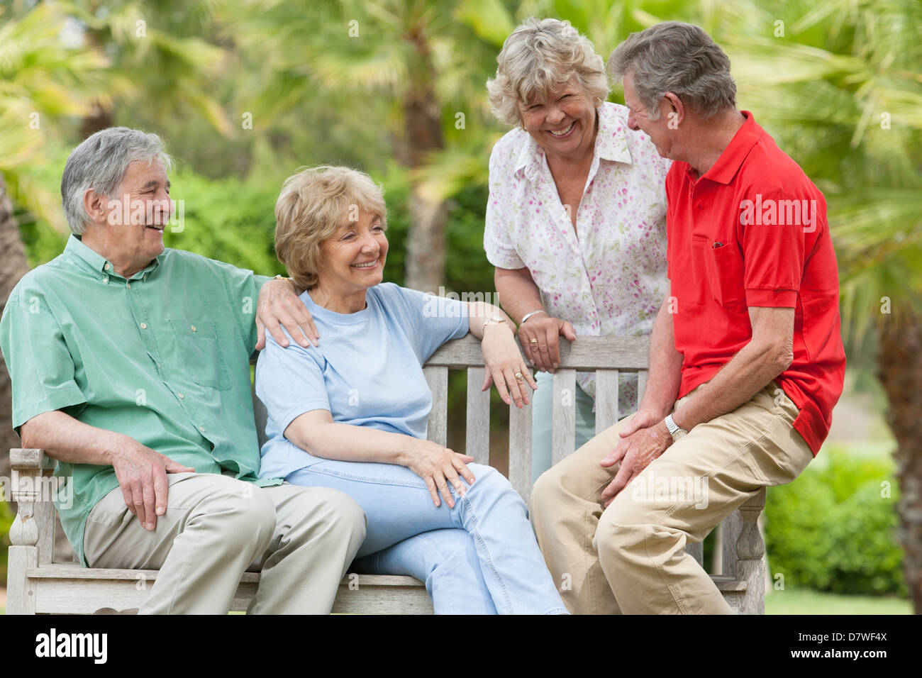 two-elderly-couples-sitting-on-a-bench-in-the-garden-D7WF4X.jpg